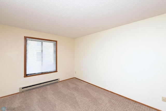 empty room featuring a baseboard heating unit, light colored carpet, a textured ceiling, and baseboards