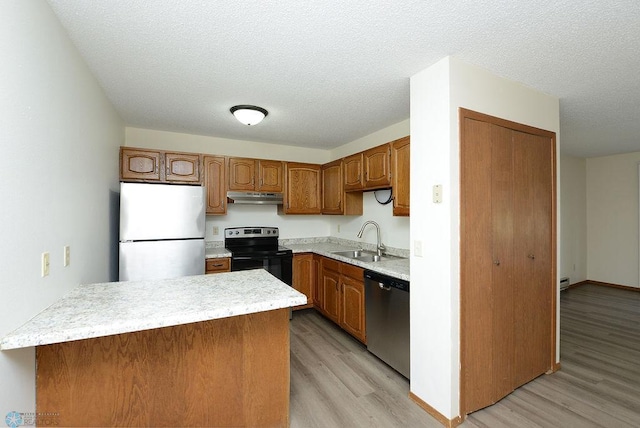 kitchen with electric stove, freestanding refrigerator, a sink, dishwasher, and under cabinet range hood