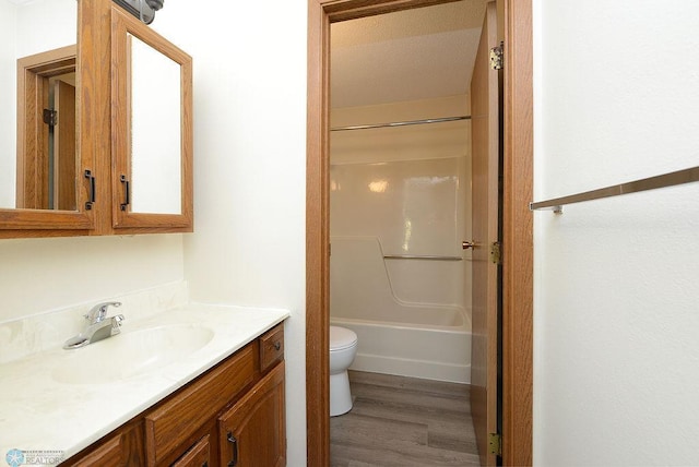 full bathroom with shower / bathing tub combination, vanity, toilet, and wood finished floors