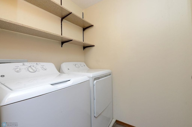 clothes washing area featuring laundry area, washer and clothes dryer, and baseboards