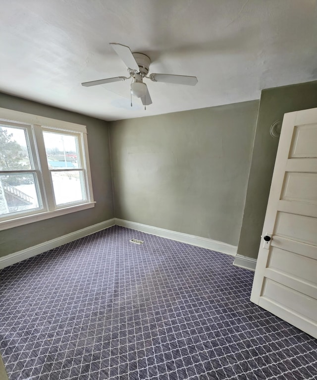 unfurnished room featuring carpet floors, baseboards, and a ceiling fan