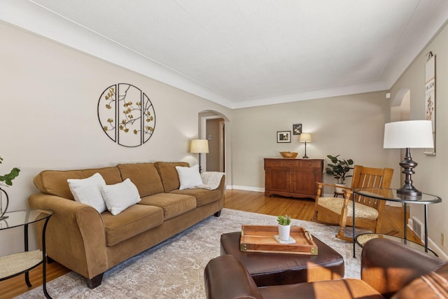 living room with baseboards, arched walkways, and wood finished floors