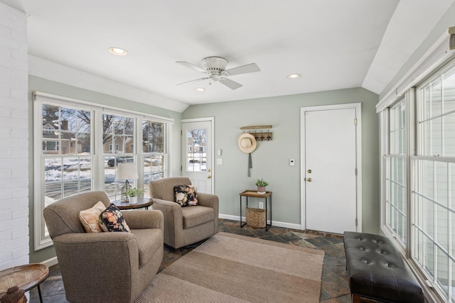 living area with recessed lighting, baseboards, stone tile floors, and vaulted ceiling