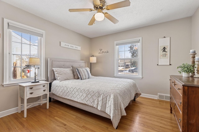 bedroom with multiple windows, visible vents, and light wood-type flooring