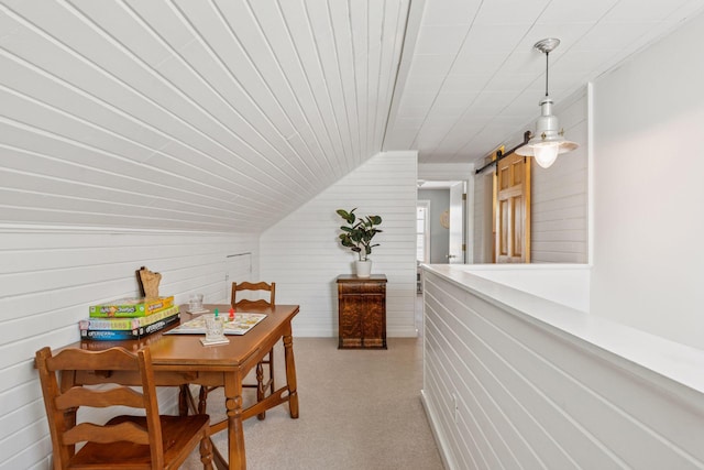 dining space featuring a barn door and lofted ceiling