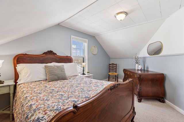 carpeted bedroom featuring baseboards and lofted ceiling