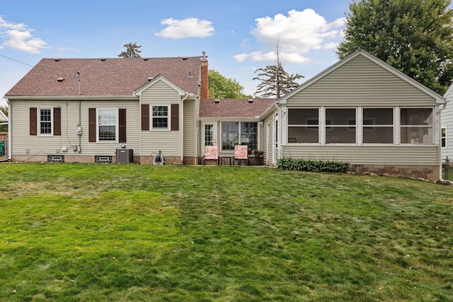 rear view of property featuring a yard, central AC unit, a chimney, and a sunroom