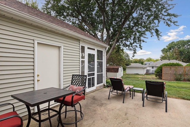 view of patio featuring an outbuilding, a storage unit, and fence