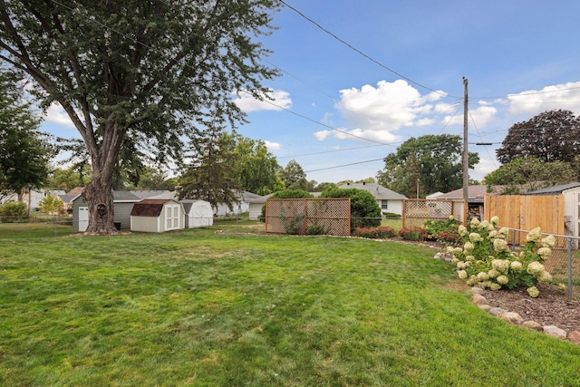 view of yard with an outbuilding, a storage shed, and a fenced backyard