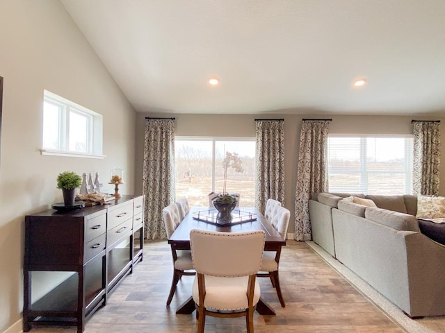 dining area featuring light wood finished floors, vaulted ceiling, and recessed lighting