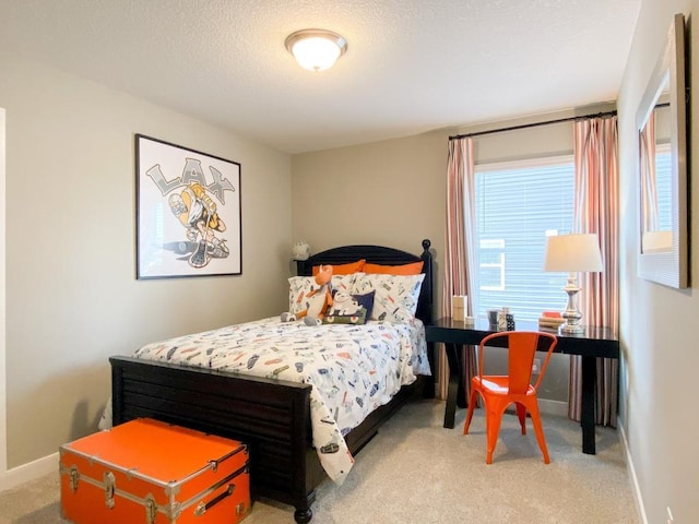 bedroom with baseboards, a textured ceiling, and light colored carpet