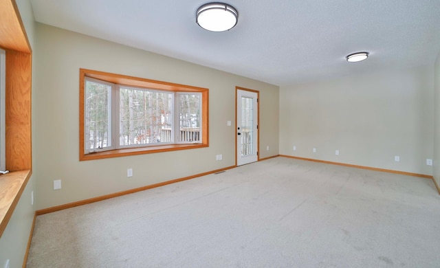 unfurnished room with baseboards and light carpet