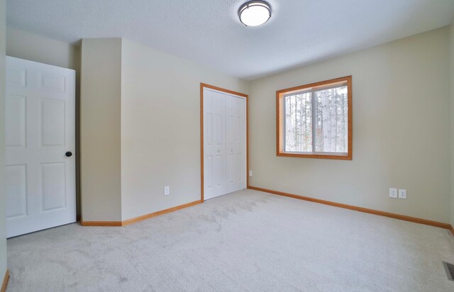 unfurnished bedroom with a closet, visible vents, carpet, and baseboards