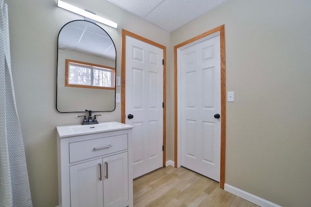 bathroom featuring vanity, baseboards, and wood finished floors