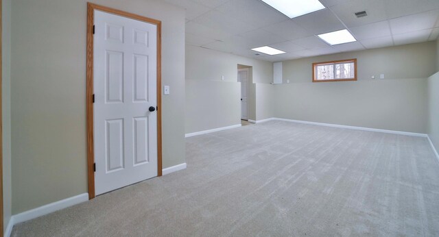 basement featuring visible vents, carpet flooring, a paneled ceiling, and baseboards