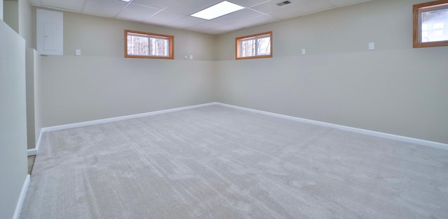 below grade area with a drop ceiling, baseboards, and a wealth of natural light