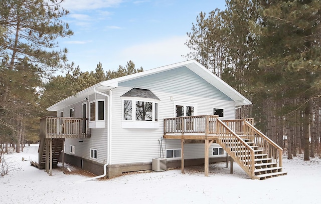 snow covered property featuring stairway, cooling unit, and a wooden deck