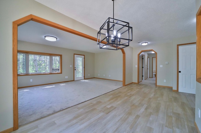 1505 Harrison Dr SW, Brainerd, MN 56401 - interior space with arched walkways, a chandelier, wood finished floors, baseboards, and a textured ceiling