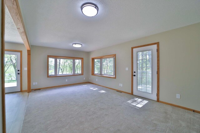 1505 Harrison Dr SW, Brainerd, MN 56401 - unfurnished living room with baseboards, a textured ceiling, and carpet