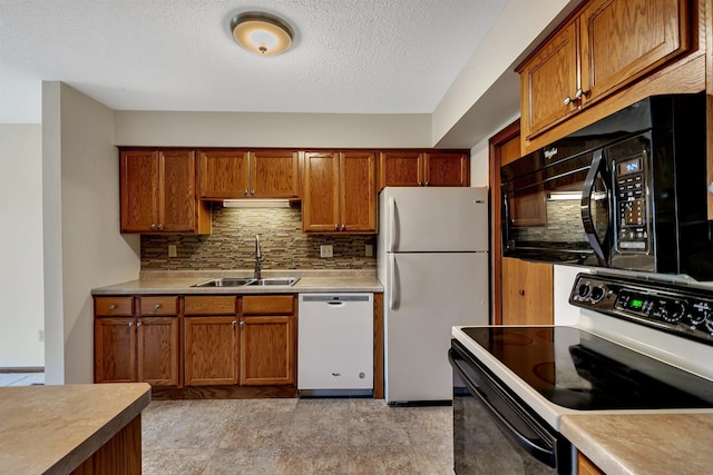 kitchen with white appliances, a sink, light countertops, tasteful backsplash, and brown cabinetry