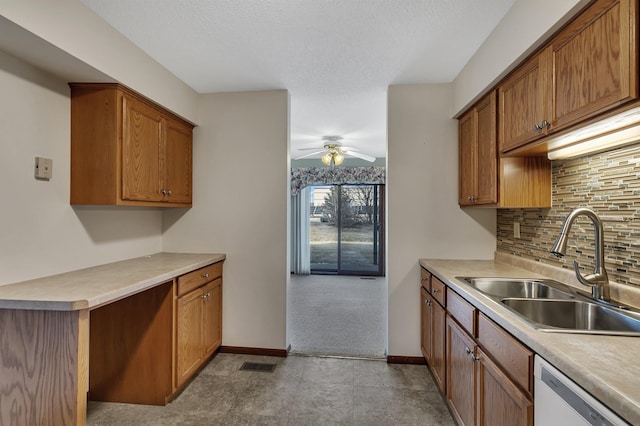 kitchen with brown cabinets, visible vents, a sink, and dishwasher