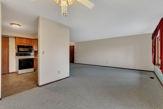 kitchen featuring light colored carpet, a ceiling fan, range with electric cooktop, black microwave, and baseboards