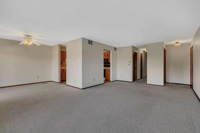 unfurnished room featuring light carpet, ceiling fan, visible vents, and baseboards