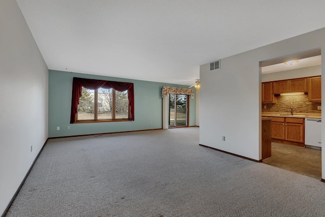 unfurnished living room featuring light carpet, baseboards, and visible vents