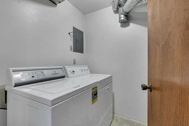 laundry room featuring laundry area, electric panel, baseboards, a textured ceiling, and separate washer and dryer