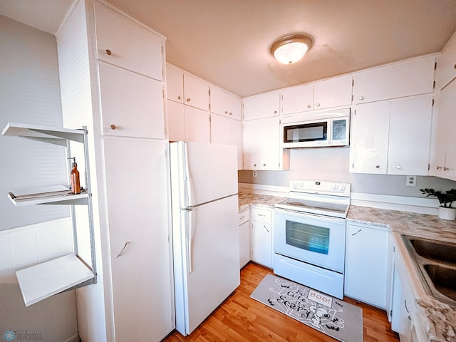 kitchen with light countertops, white appliances, white cabinetry, and light wood-style floors