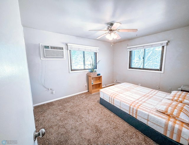 bedroom with a ceiling fan, a baseboard heating unit, an AC wall unit, carpet flooring, and baseboards