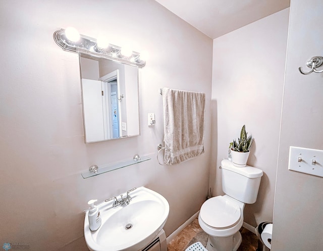 bathroom with baseboards, a sink, and toilet