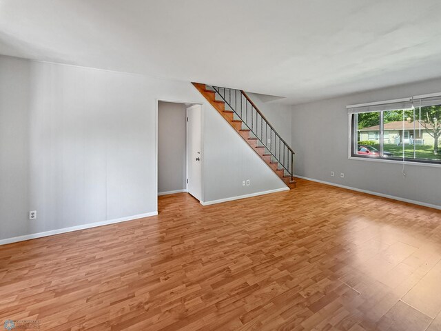 2815 9th St N Unit B4, Fargo, ND 58102 - unfurnished living room with light wood-type flooring, stairs, and baseboards