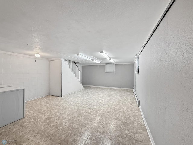 2815 9th St N Unit B4, Fargo, ND 58102 - finished below grade area featuring a textured ceiling, a textured wall, stairway, light flooring, and baseboards