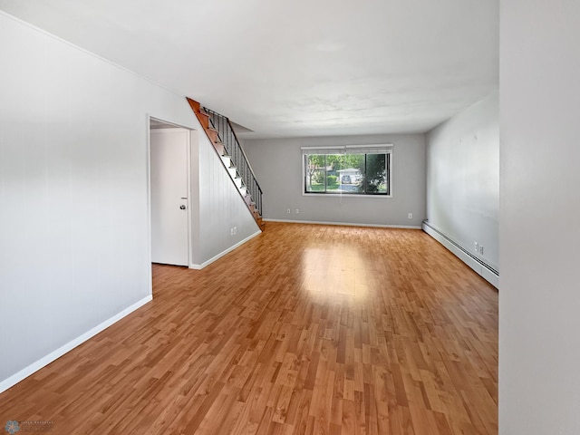 2815 9th St N Unit B4, Fargo, ND 58102 - spare room featuring a baseboard radiator, stairway, light wood-style floors, and baseboards