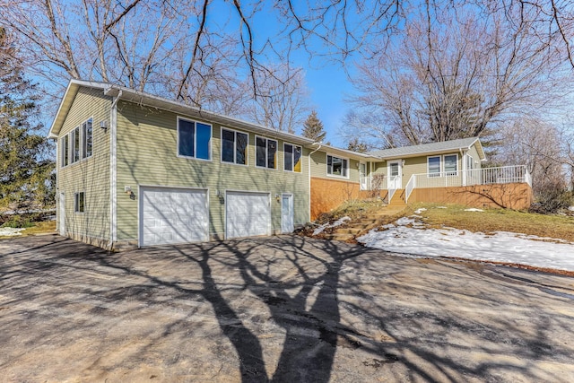 view of front of property featuring aphalt driveway, covered porch, and a garage