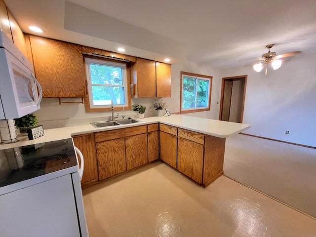 13857 Jacob Ave, Nininger Twp, MN 55033 - kitchen featuring white appliances, a peninsula, brown cabinetry, light countertops, and recessed lighting