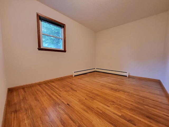 13857 Jacob Ave, Nininger Twp, MN 55033 - empty room with light wood-style floors and a baseboard radiator