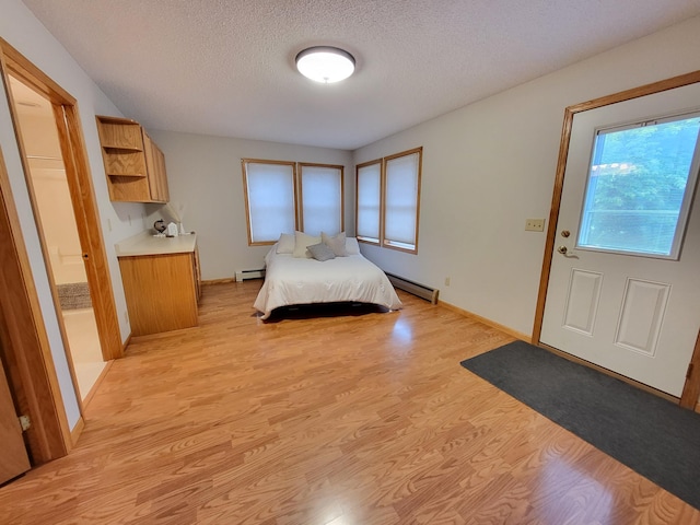 13857 Jacob Ave, Nininger Twp, MN 55033 - bedroom with a baseboard heating unit, a textured ceiling, and light wood-type flooring