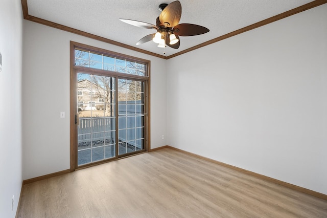 spare room featuring light wood-type flooring, a textured ceiling, baseboards, and crown molding