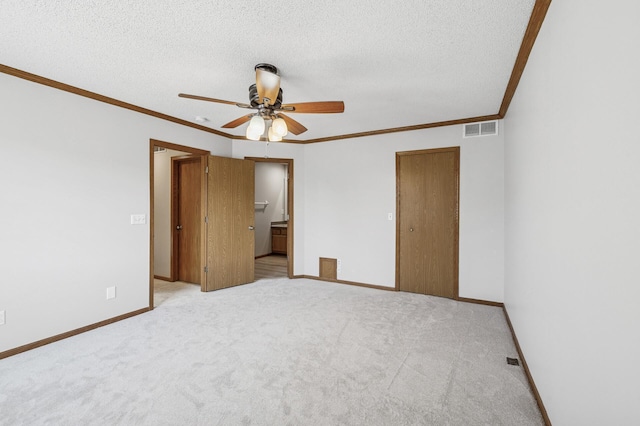 unfurnished bedroom featuring baseboards, visible vents, a textured ceiling, and carpet flooring