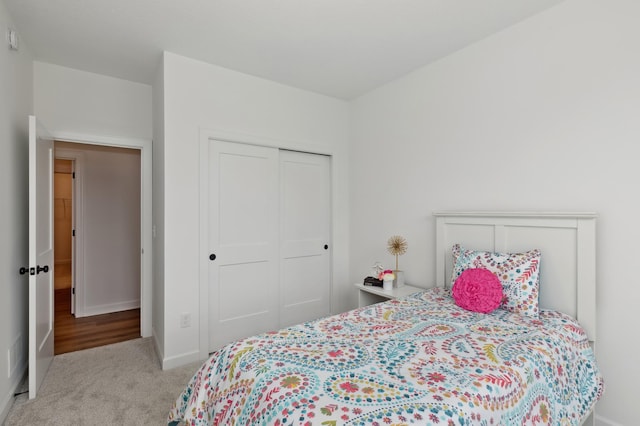 bedroom with a closet, baseboards, and carpet flooring