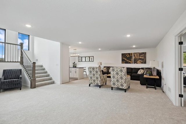 living room with stairway, recessed lighting, and light colored carpet