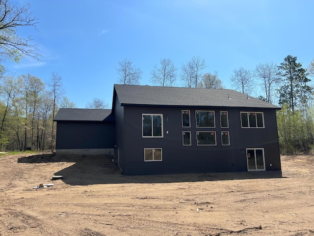 rear view of property featuring roof with shingles