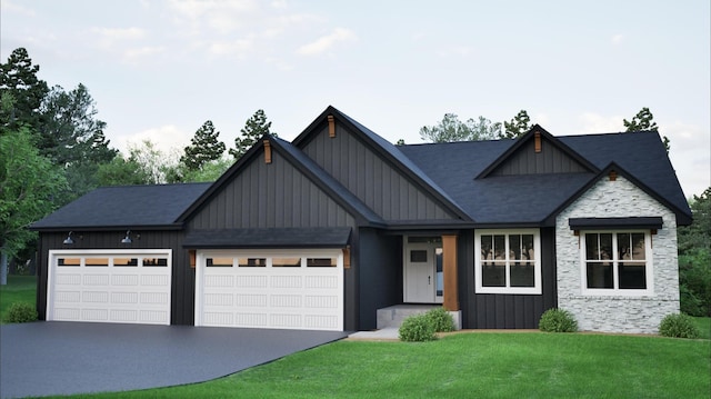 view of front of house with board and batten siding, asphalt driveway, a front lawn, stone siding, and a garage