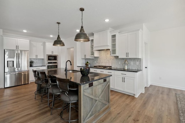 kitchen featuring stainless steel appliances, a sink, white cabinetry, and recessed lighting