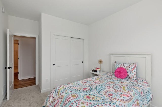 bedroom with carpet, a closet, and baseboards