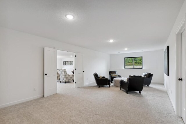 living area with light colored carpet, recessed lighting, and baseboards