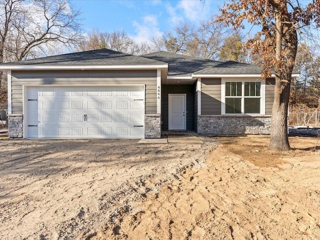 view of front of house with an attached garage and stone siding