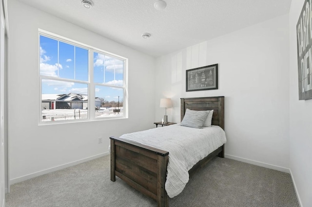 bedroom with baseboards, carpet, and a textured ceiling